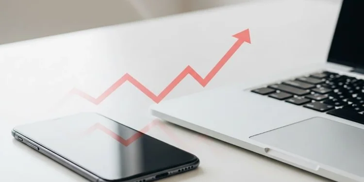 Smartphone and laptop with an upward trending arrow symbolizing the tariffs impact on technology and rising costs.