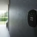 Frontal view of the Ecobee Smart Thermostat Premium showing the 72 degree temperature and air quality monitor on a slate wall.