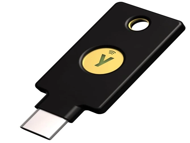 A black YubiKey 5C NFC hardware security key featuring a gold contact button and a USB-C connector sits on a white background.