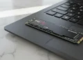 Samsung 990 Pro 2TB NVMe SSD sitting on a black laptop trackpad for a high speed storage upgrade