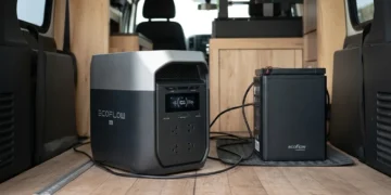 EcoFlow portable power station connected to an extra battery inside a camper van with a wooden floor